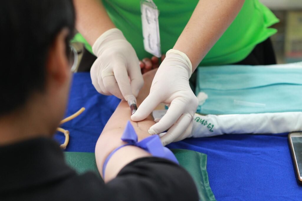 pexels-photo-1350560-1350560-1 A healthcare professional administering an injection to a patient's arm during a medical procedure.